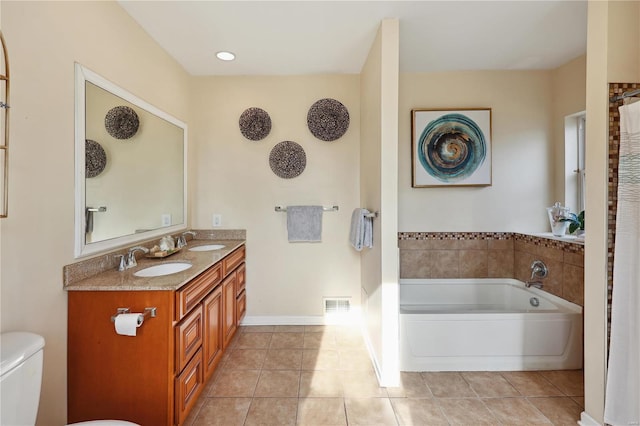 bathroom featuring tile patterned floors, a tub, vanity, and toilet