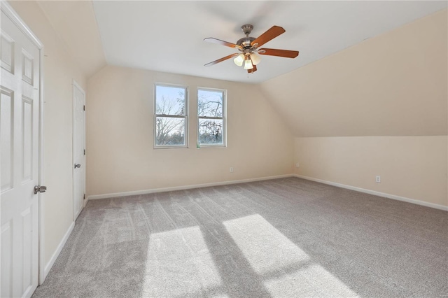 additional living space featuring ceiling fan, light colored carpet, and vaulted ceiling