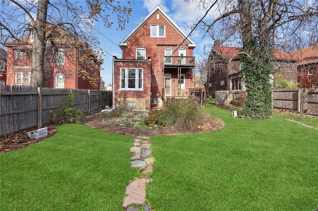 rear view of property with a yard and a balcony