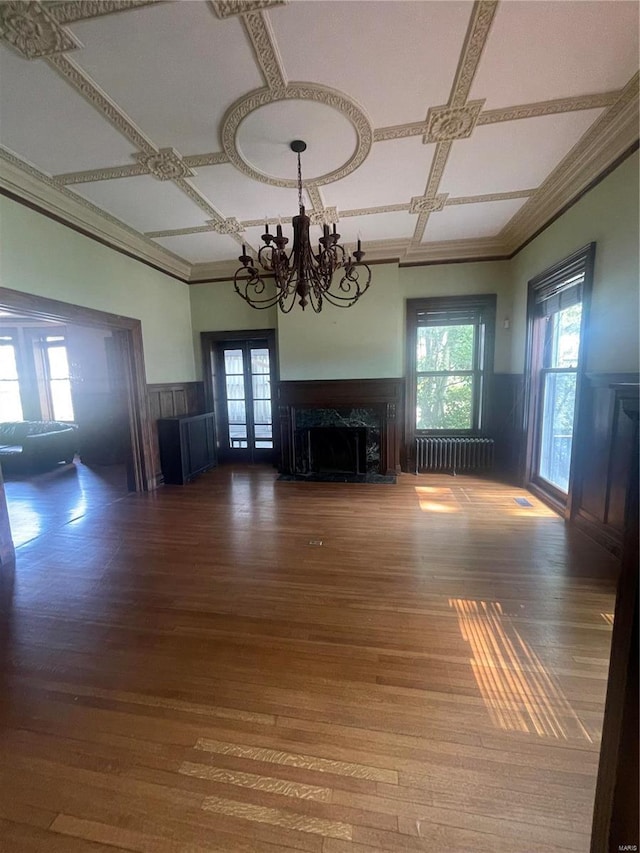 unfurnished living room with hardwood / wood-style floors, a fireplace, radiator heating unit, and coffered ceiling