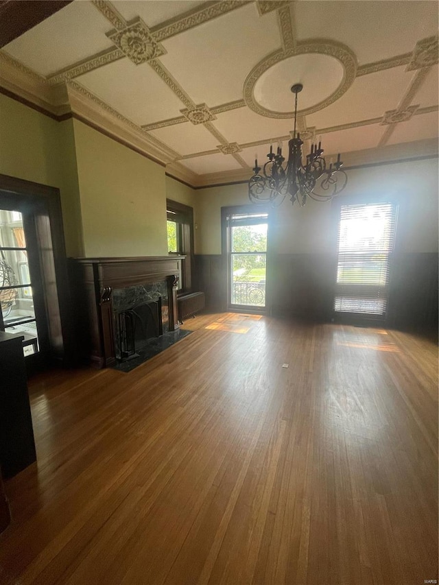 unfurnished living room featuring a fireplace, wood-type flooring, a chandelier, and coffered ceiling