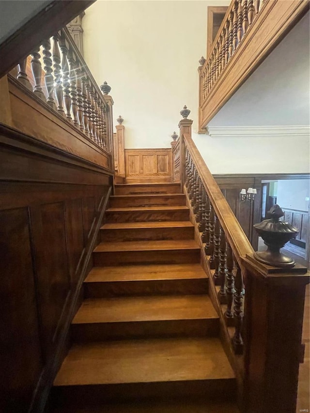 stairway featuring hardwood / wood-style flooring and crown molding