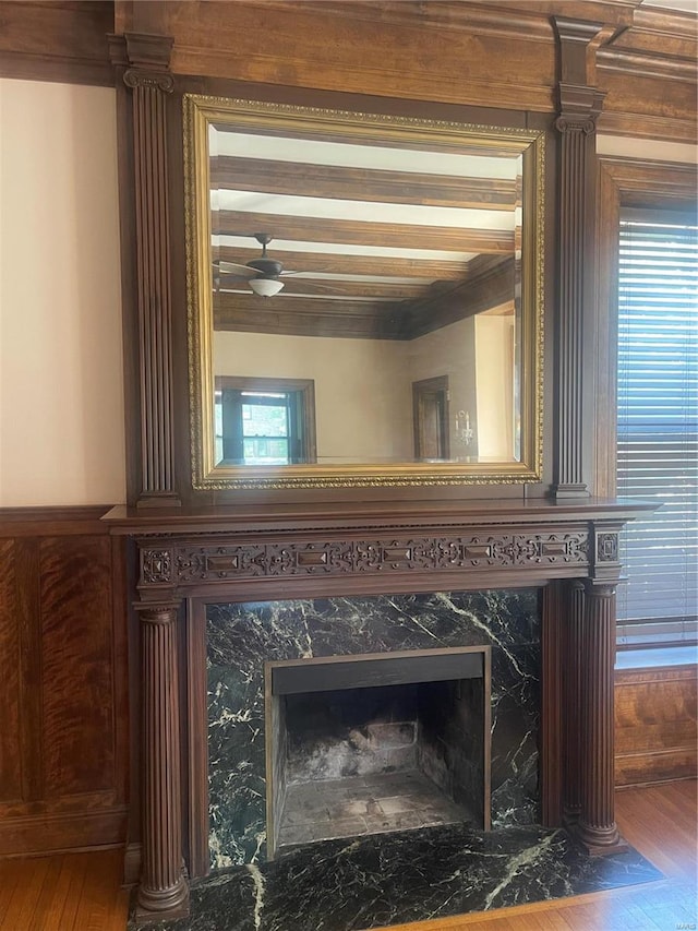 room details with a premium fireplace, wood-type flooring, and beam ceiling