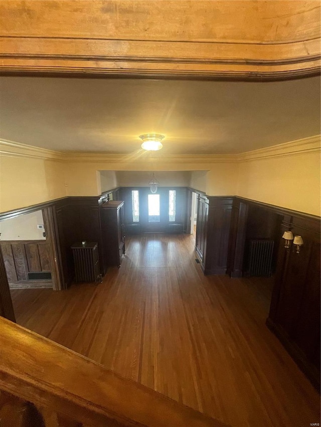 hallway with dark wood-type flooring and ornamental molding