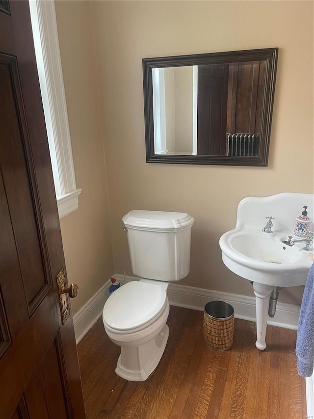 bathroom featuring wood-type flooring and toilet