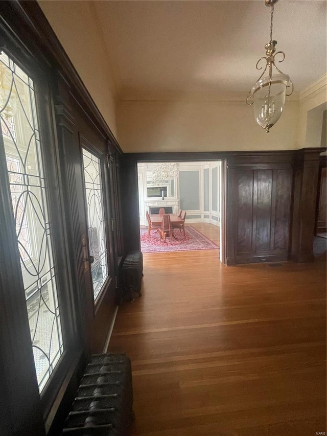 foyer entrance with ornamental molding, dark hardwood / wood-style flooring, and a notable chandelier