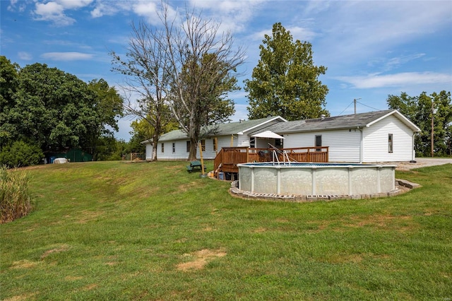 back of house featuring a lawn and a swimming pool side deck