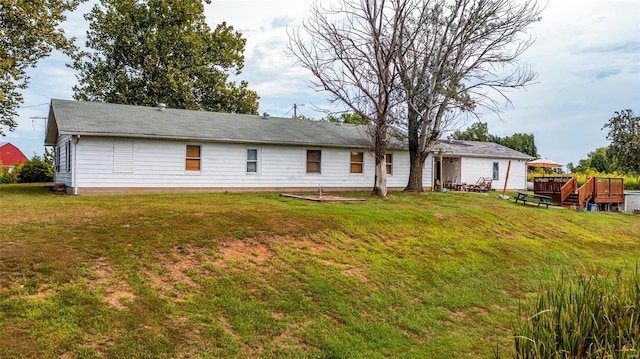 view of front facade with a deck and a front yard