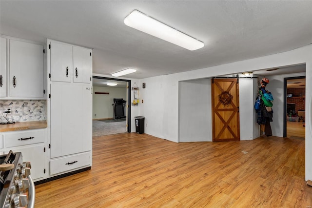 basement with light hardwood / wood-style flooring, a barn door, and a fireplace