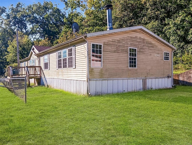 view of side of home featuring a yard and a wooden deck