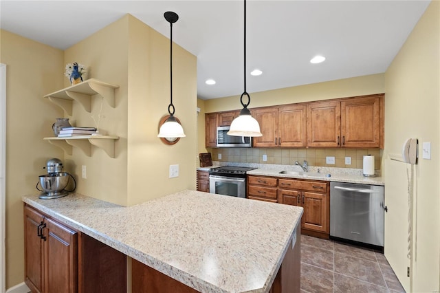 kitchen featuring kitchen peninsula, tasteful backsplash, hanging light fixtures, sink, and stainless steel appliances