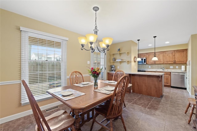 tiled dining space featuring a chandelier