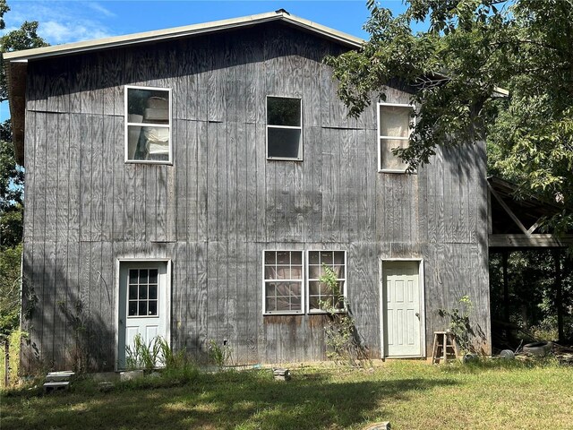 rear view of property featuring a yard