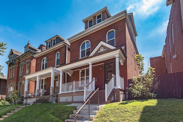 view of front of home with covered porch and a front lawn