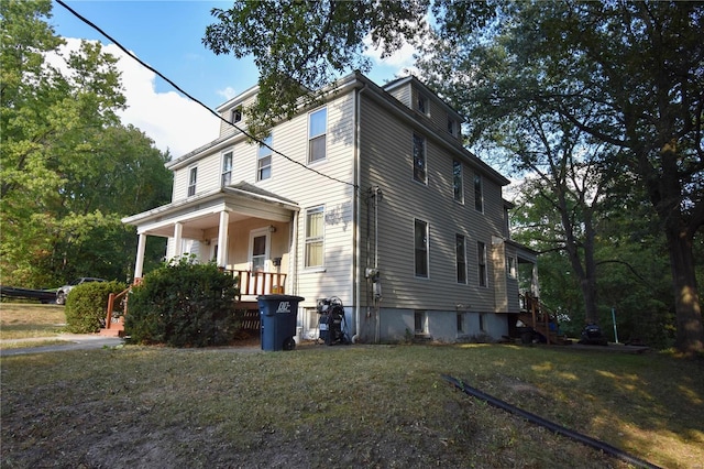 view of home's exterior featuring a lawn and a porch