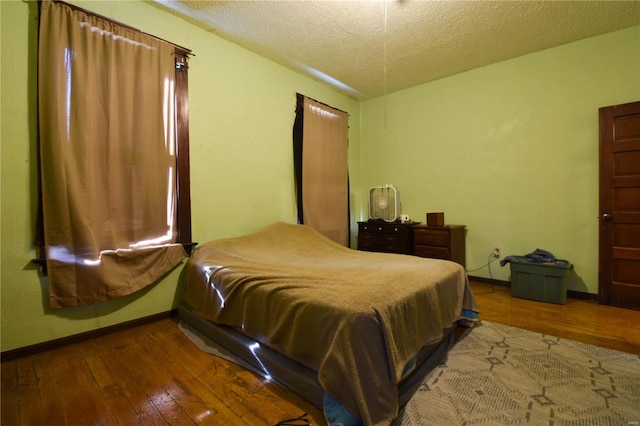 bedroom featuring wood-type flooring and a textured ceiling