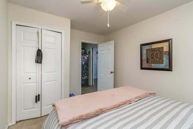 carpeted bedroom with ceiling fan and a closet