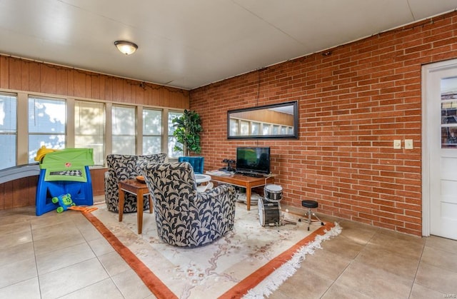 interior space featuring tile patterned flooring and brick wall