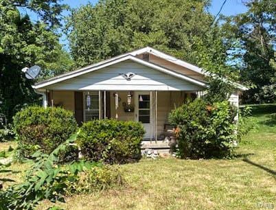 view of outbuilding with a yard and a porch