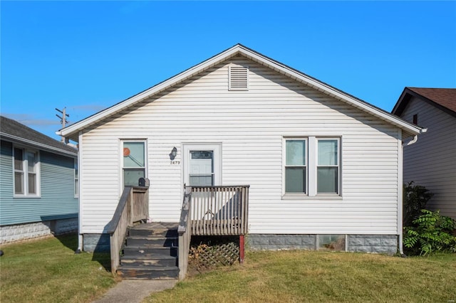 rear view of house with a wooden deck and a lawn