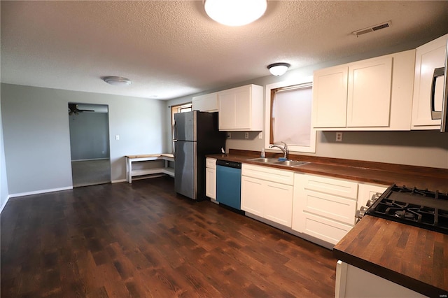 kitchen with butcher block countertops, sink, stainless steel appliances, and white cabinets