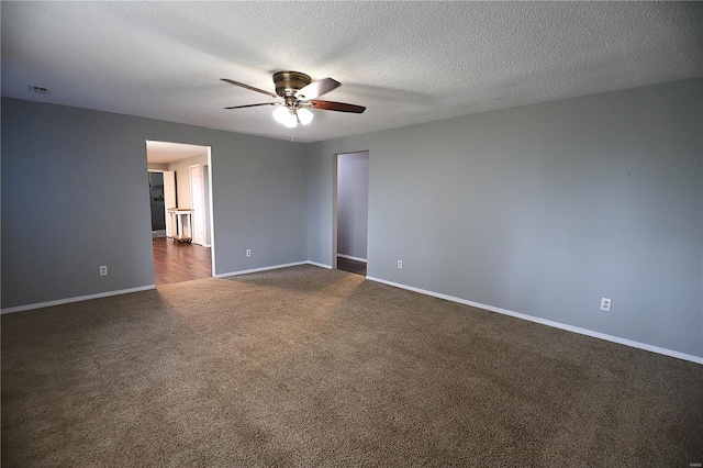 spare room featuring ceiling fan, a textured ceiling, and dark colored carpet