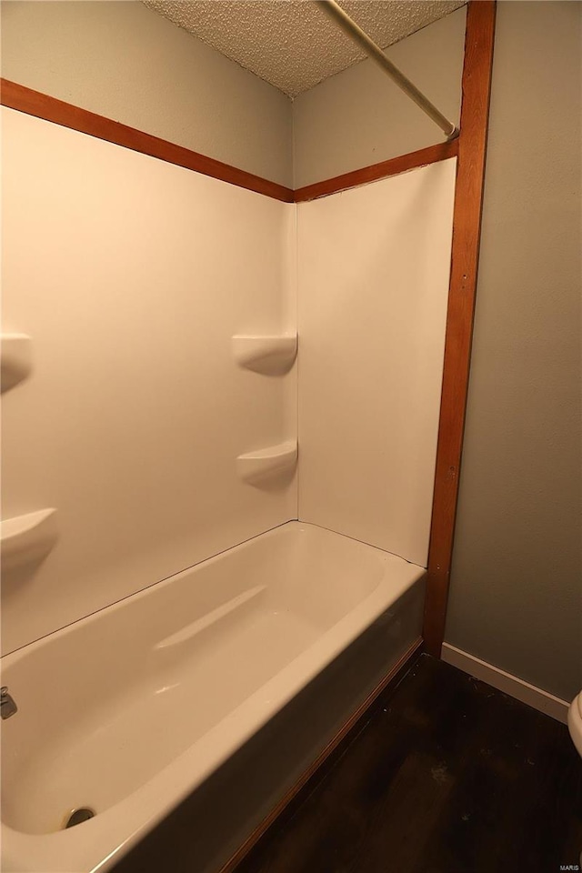 bathroom featuring a textured ceiling and bathtub / shower combination