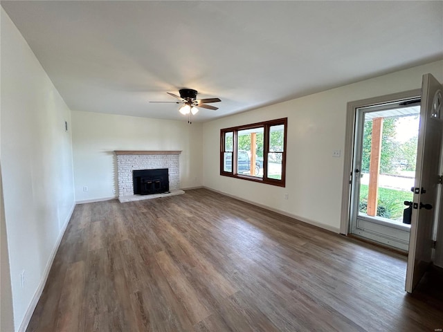 unfurnished living room with a fireplace, ceiling fan, and dark hardwood / wood-style floors