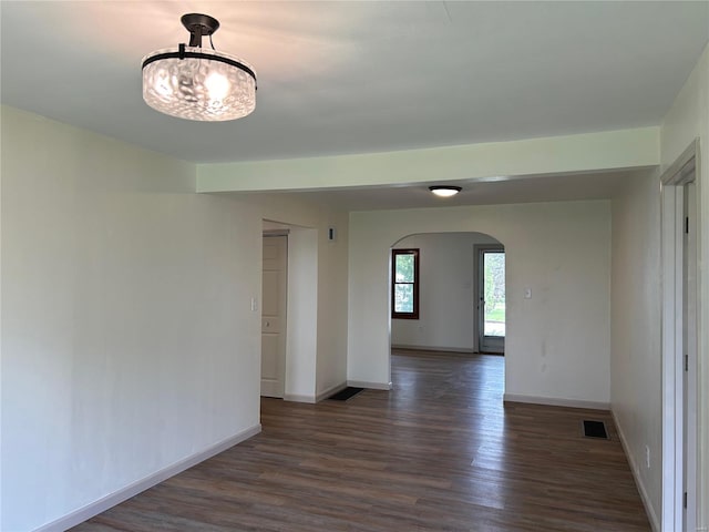 unfurnished room featuring a chandelier and dark hardwood / wood-style flooring