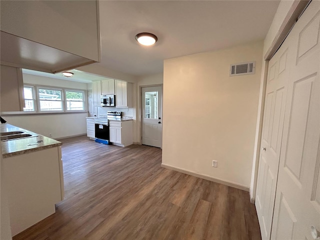 kitchen with white cabinets, wood-type flooring, stainless steel appliances, and sink