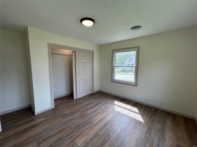 unfurnished bedroom featuring dark hardwood / wood-style floors and a closet