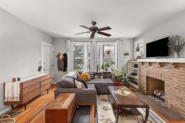 living room with ceiling fan, light hardwood / wood-style flooring, and a fireplace