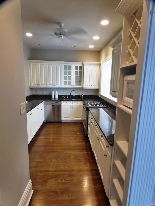 kitchen featuring white cabinetry, stainless steel appliances, sink, ceiling fan, and dark wood-type flooring