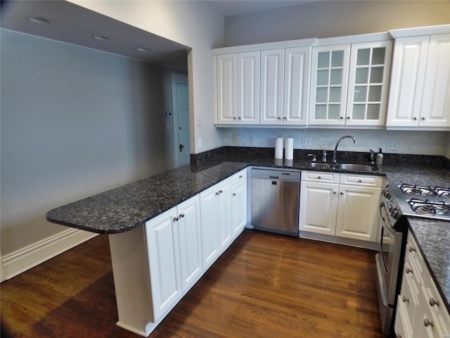 kitchen featuring dark wood-type flooring, appliances with stainless steel finishes, white cabinetry, and sink