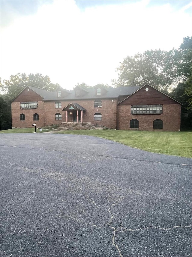 ranch-style house featuring a front lawn and central air condition unit