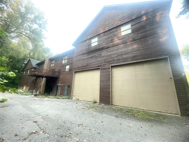 view of property exterior featuring a garage and a deck