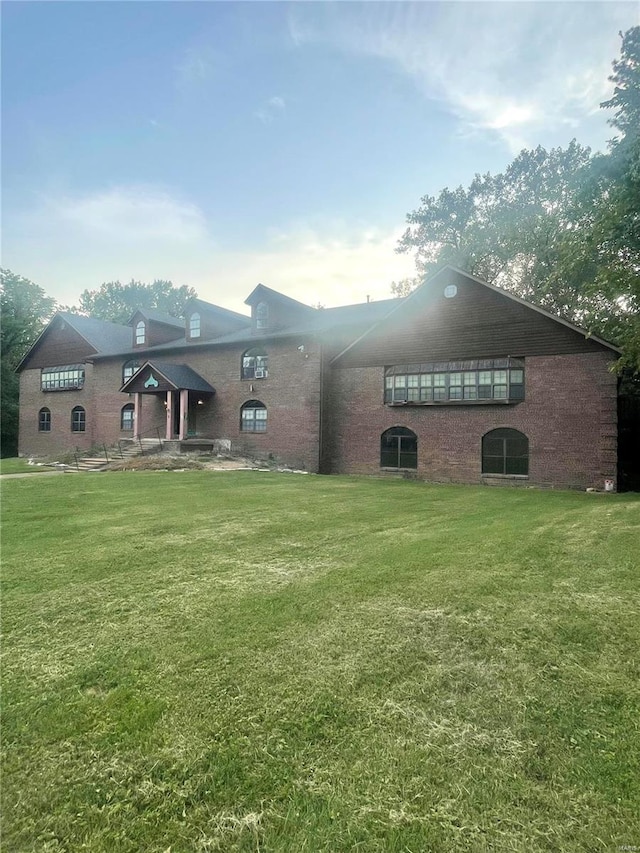 rear view of house featuring a lawn