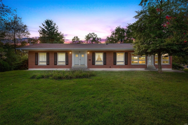 ranch-style home with a yard