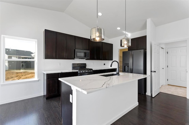 kitchen with dark hardwood / wood-style floors, a center island with sink, pendant lighting, appliances with stainless steel finishes, and sink