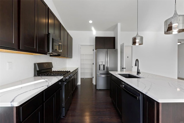 kitchen featuring light stone counters, stainless steel appliances, sink, dark hardwood / wood-style floors, and pendant lighting