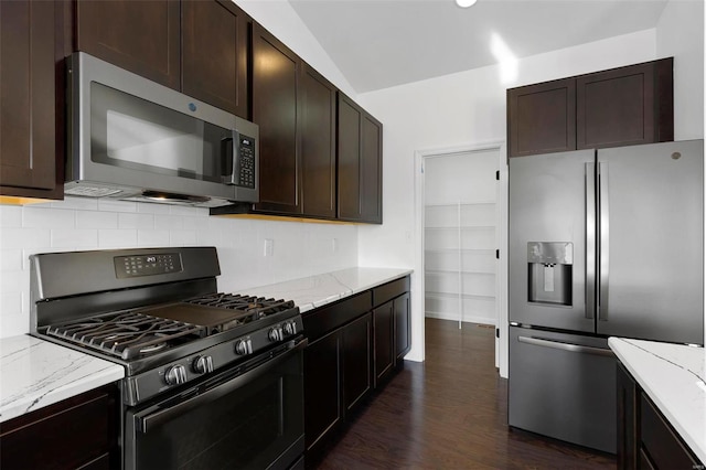 kitchen with appliances with stainless steel finishes, dark brown cabinetry, and dark hardwood / wood-style floors