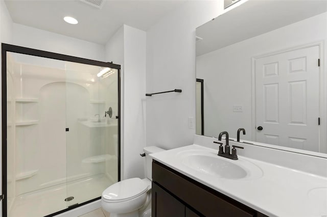 bathroom featuring a shower with door, vanity, toilet, and tile patterned floors