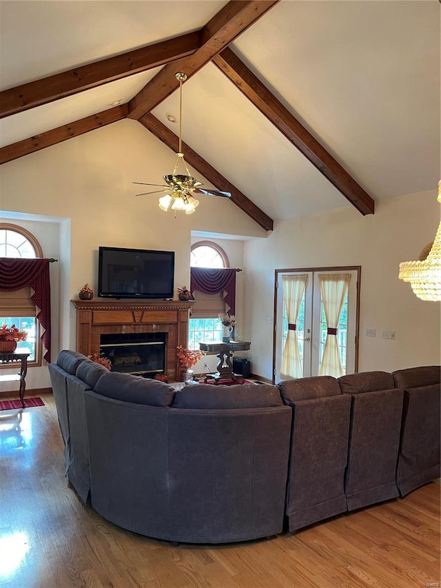 living room with high vaulted ceiling, ceiling fan, beamed ceiling, hardwood / wood-style flooring, and a fireplace