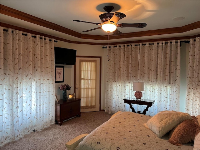 carpeted bedroom with ornamental molding, ceiling fan, and a tray ceiling