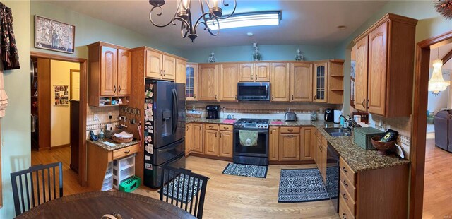 kitchen with pendant lighting, backsplash, stone counters, and black appliances