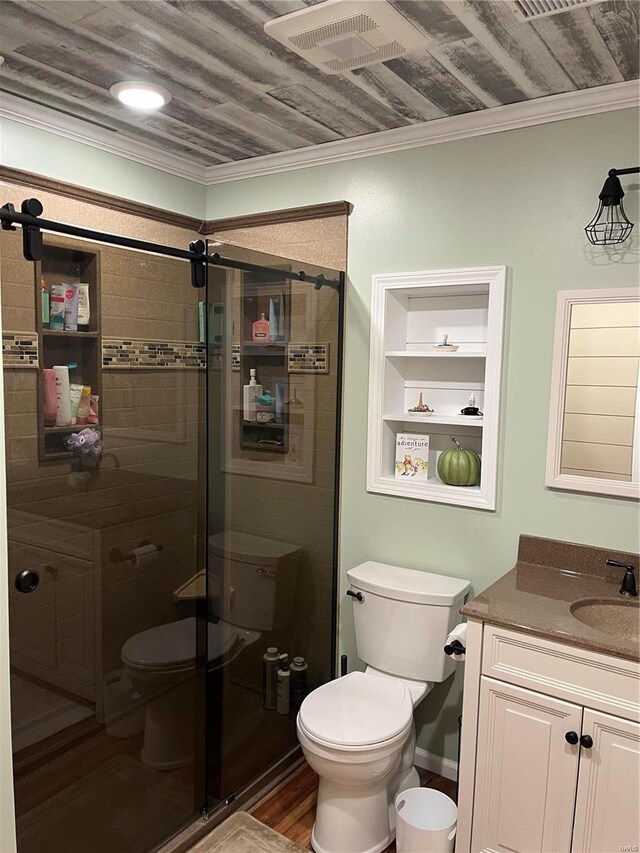 bathroom featuring toilet, ornamental molding, a shower with door, hardwood / wood-style flooring, and vanity