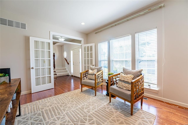 living area with french doors and hardwood / wood-style floors