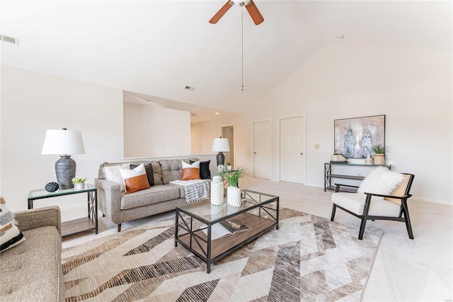 carpeted living room with ceiling fan and high vaulted ceiling