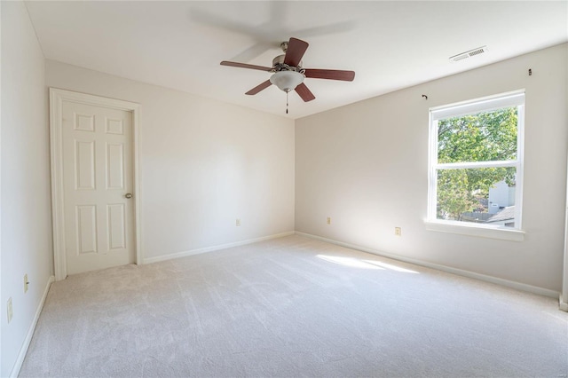 spare room featuring light colored carpet and ceiling fan