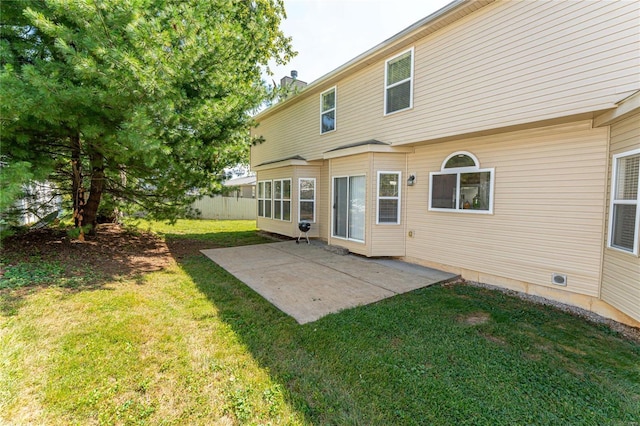 rear view of property featuring a patio and a lawn